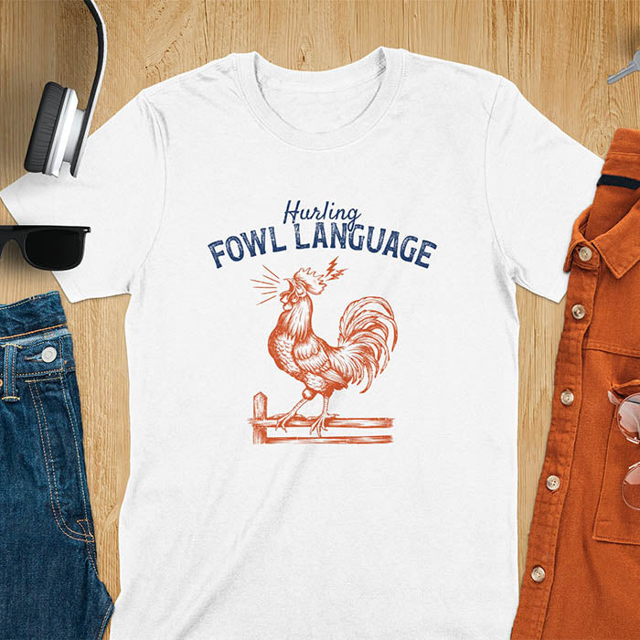 Vintage t-shirt with line art drawing of a chicken rooster standing on a fence in a farm crowing with exaggerated open beak. The design gives a fun and quirky vibe. Text says hurling fowl language.