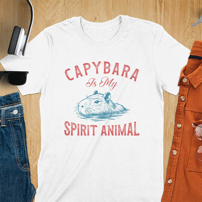 The design features a blue illustration of a capybara's head partly submerged in water and the text "CAPYBARA Is My SPIRIT ANIMAL" in red. This playful and trendy statement captures the calm and social nature of the capybara.
