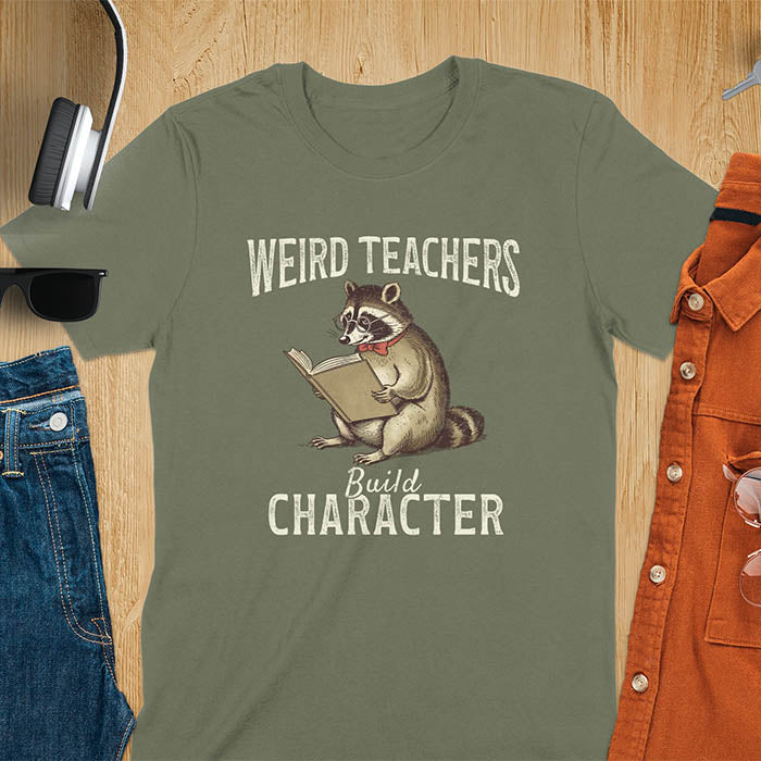 Weird Teachers Build Character shirt featuring a raccoon reading a book with glasses and a red bow tie. Vintage distressed font and brownish monotone give it a retro look. Perfect back-to-school shirt, funny teacher gift, or teacher appreciation tee.