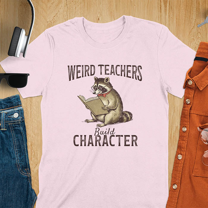 Weird Teachers Build Character shirt featuring a raccoon reading a book with glasses and a red bow tie. Vintage distressed font and brownish monotone give it a retro look. Perfect back-to-school shirt, funny teacher gift, or teacher appreciation tee.