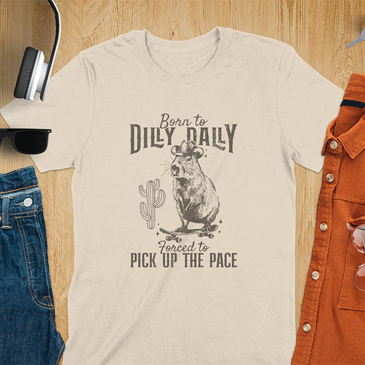 Capybara in a cowboy hat on a skateboard western style. Born to Dilly Dally and Forced to Pick Up the Pace text. Distressed style.