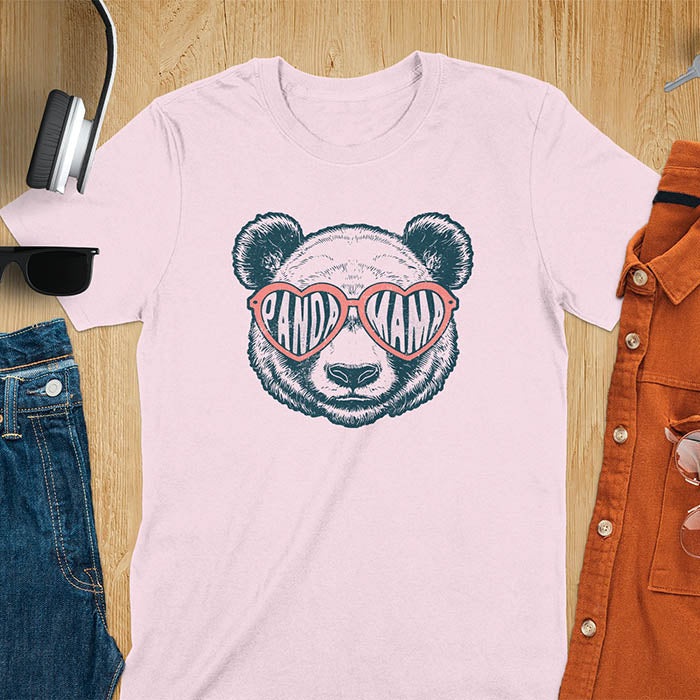 A t-shirt featuring a white panda face with pink heart-shaped sunglasses that spell PANDA MAMA. This mama shirt is a vintage mama t-shirt for a funny animal mom. A mom tee for a gift for mom or gift for grandmother. A mom birthday gift or gift for wife, or an expectant mom gift for a pregnancy announce. A great mother days shirt for mama.