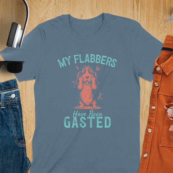 A t-shirt with a startled basset hound puppy. Its characteristic drooping ears are shown, and small lightning bolts radiate from its head. Text: "MY FLABBERS Have Been GASTED". This cute dog tee-shirt displays dog cuteness & cuteness puppy. A funny dog shirt & dog lover gift for dog person, dog mom, dog dad, dog owner. A retro dog shirt & vintage dog tee, animal person gift, gift for mom, hers.
