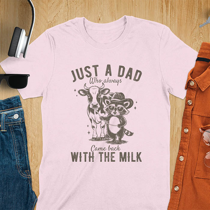 A t-shirt with a raccoon wearing a cowboy hat and sunglasses, holding a leash to a cow. Text: Just a Dad WHO ALWAYS above and Came Back WITH THE MILK below. This funny raccoon shirt features funny graphics, a dad t shirt for a funny fathers day or fathers day gift. A funny shirt for dad or gift for dad, a husband gift or father in law gifts. Could be used for a dad announcement, expectant dad, or godfather proposal.
