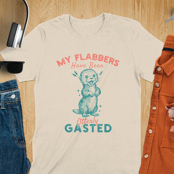 A t-shirt with a startled-looking otter holding its paws in front of its chest. Sparkles surround the otter. Text: "MY FLABBERS" above and "HAVE BEEN Otterly GASTED" below. This weird silly funny tee shows Kawaiiness cuteness and Otter cuteness, a great Otter lover gift. A Sarcastic t-shirt and Funny gag gift, a Gen Z meme tee tapping into Weirdcore memes. An Animal person gift and Gift for mom, hers, one of the Shirts that go hard featuring a Cute sea otter.