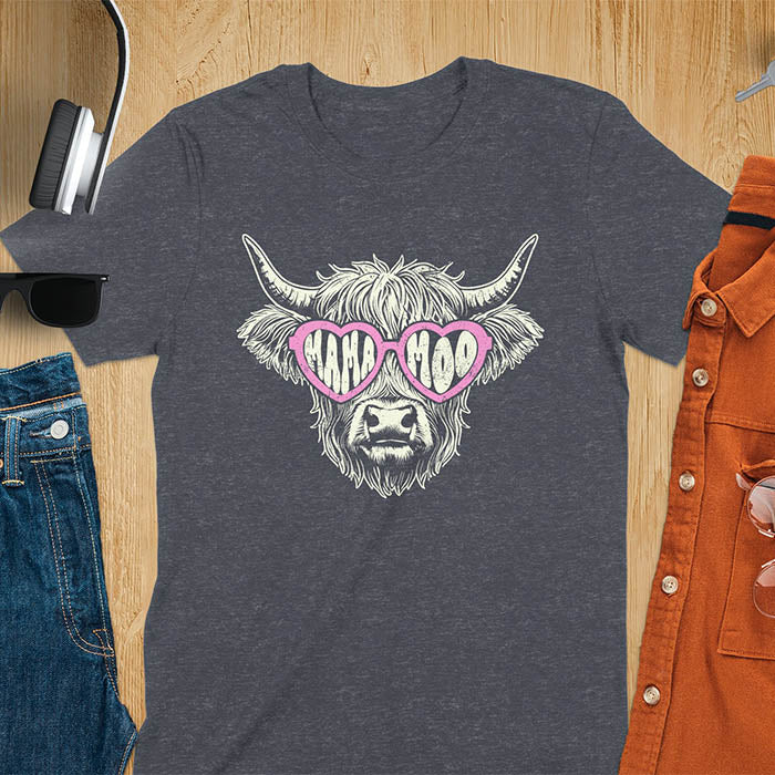 A t-shirt featuring a fluffy highland cow face with long horns, wearing pink heart-shaped sunglasses spelling MAMA MOO. Below the cow, Veronica is written in script font. This retro mom tee-shirt design is a cute cow highlander for mama mom life. A funny animal mom tee for an expecting mom or pregnant mom gift, ideal for a pregnancy announcement or pregnancy reveal. A great mom gift or Mother days gift, or a new mom gift for a gift for wife. The name can be personalized.