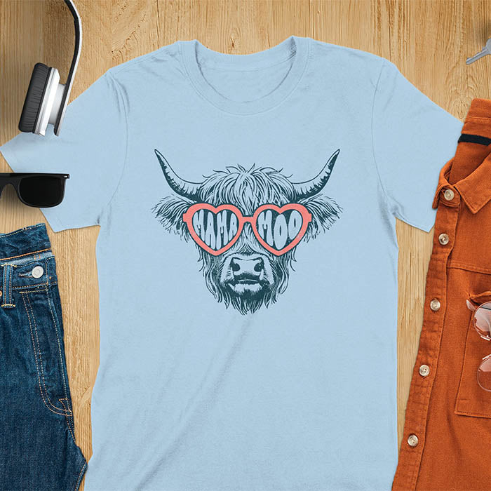 A t-shirt featuring a fluffy highland cow face with long horns, wearing pink heart-shaped sunglasses spelling MAMA MOO. Below the cow, Veronica is written in script font. This retro mom tee-shirt design is a cute cow highlander for mama mom life. A funny animal mom tee for an expecting mom or pregnant mom gift, ideal for a pregnancy announcement or pregnancy reveal. A great mom gift or Mother days gift, or a new mom gift for a gift for wife. The name can be personalized.