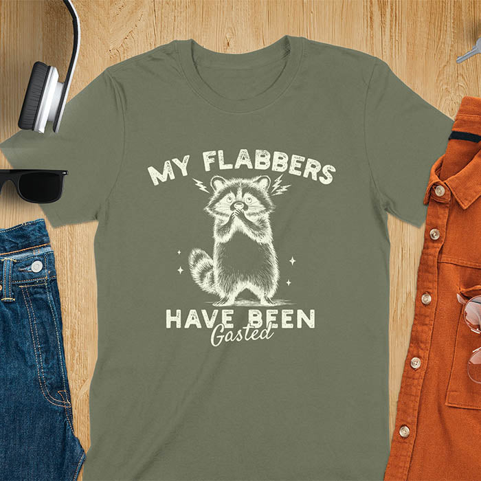 A t-shirt featuring a raccoon with wide eyes and paws covering its mouth. Text: MY FLABBERS above and HAVE BEEN Gasted below in a distressed font. This sarcastic tee-shirt features a funny raccoon with kawaiiness cuteness, a genz meme tee or anxiety tshirt. A depress meme and weirdcore memes design, a funny gag gift for sad core fans. This is one of those shirts that go hard, a trash panda design.