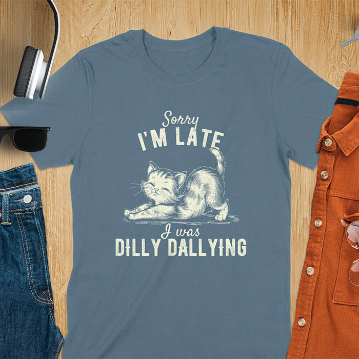 A t-shirt with a kitten stretching its back. Text: Sorry I'M LATE above and I was DILLY DALLYING below. This cat lover shirt features cat cuteness gift and kawaiiness cuteness. A sarcastic meme shirt about dilly dally, a funny genz meme with funny animals. This kawaii kitten design has vintage aesthetics, a snarky humorous tee, an animal person gift or mom gift hers. A cat mom t shirt alternative.