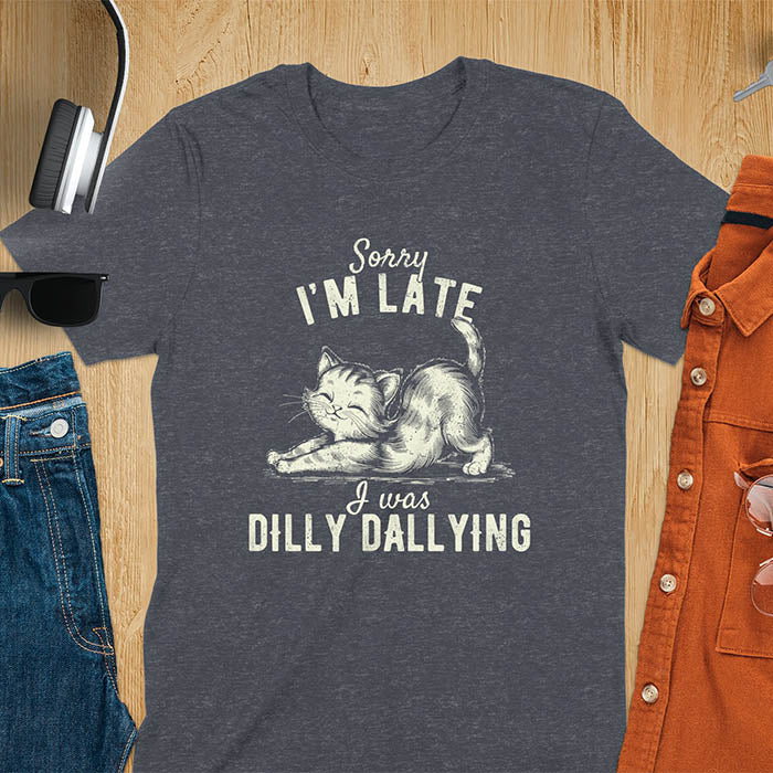 A t-shirt with a kitten stretching its back. Text: Sorry I'M LATE above and I was DILLY DALLYING below. This cat lover shirt features cat cuteness gift and kawaiiness cuteness. A sarcastic meme shirt about dilly dally, a funny genz meme with funny animals. This kawaii kitten design has vintage aesthetics, a snarky humorous tee, an animal person gift or mom gift hers. A cat mom t shirt alternative.