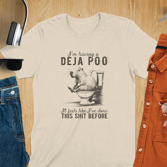 A t-shirt with a capybara seated on a toilet bowl. Text: "I'm having a Deja Poo It feels like I've done THIS SHIT BEFORE". A Capybara Deja Poo Shirt with Toilet Humor Gag Gift appeal. Inappropriate, offensive, weirdcore, funny meme, trending meme, genz gen z tee. Features kawaiiness, capybara cuteness, weird capybara gift. Great for animal person, pet lovers, animal lover, gift mom hers. A Retro Graphic Tshirt, y2k tee-shirt, Vintage Silly Party Tees, shirts that go hard.