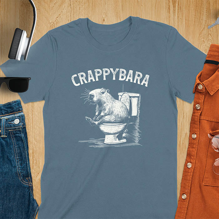 A t-shirt with a capybara on a toilet. Text: "CRAPPYBARA". This Crappybara Tshirt is an inappropriate shirt, offensive shirt & Toilet Humor Gag Gift. A Funny Meme Tee-shirt, Trending meme shirt, genz gen z weirdcore t-shirt. Features Kawaiiness Kawaiiful, Capybara cuteness, Weird capybara gift, Funny Vintage Capybara Shirt. For animal person gift, pet lovers tee, Animal Lover T-shirt, gift mom hers. A Y2K tee-shirt, Vintage Silly Party Tees, shirts that go hard.