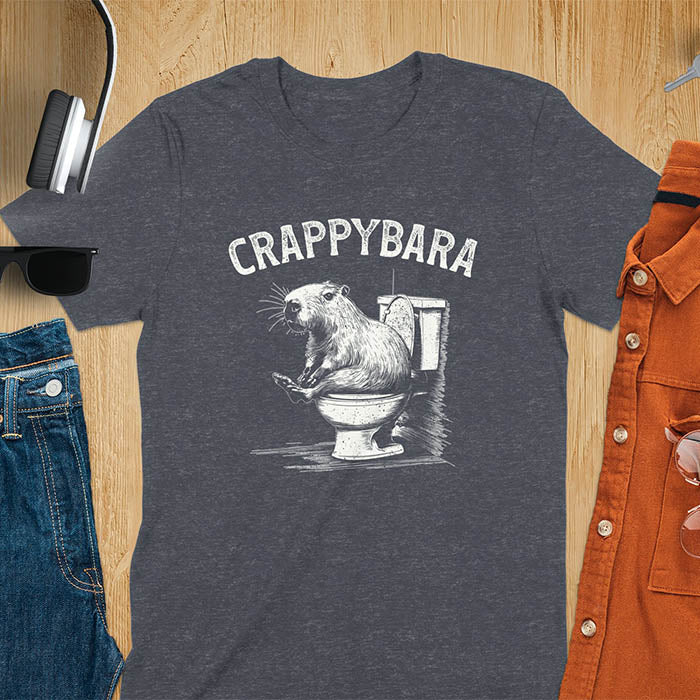 A t-shirt with a capybara on a toilet. Text: "CRAPPYBARA". This Crappybara Tshirt is an inappropriate shirt, offensive shirt & Toilet Humor Gag Gift. A Funny Meme Tee-shirt, Trending meme shirt, genz gen z weirdcore t-shirt. Features Kawaiiness Kawaiiful, Capybara cuteness, Weird capybara gift, Funny Vintage Capybara Shirt. For animal person gift, pet lovers tee, Animal Lover T-shirt, gift mom hers. A Y2K tee-shirt, Vintage Silly Party Tees, shirts that go hard.