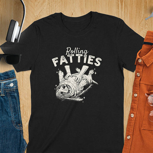 A t-shirt with a basset hound dog on its back getting a belly rub. Text: "Rolling FATTIES". This Rolling Fatties Dog Shirt is a Basset Hound Owner T-shirt, basset hound tee. A Funny Graphic Tee for Dog cuteness gift, Doggy doggie gift, Kawaii Cute Fat Puppy. Perfect gift for dog lover, Dog dad shirt, Dog mama shirt, Dog owner tshirt, pet vintage shirt, Pet lover apparel, Animal Lover Gift, Dog person clothe, Gift mom hers. An Unhinged Tee-shirt, Retro dog shirt, Vintage dog tee.