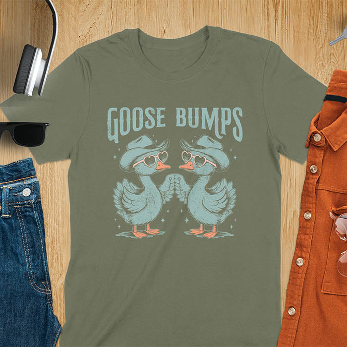 A t-shirt with two geese in cowboy hats and heart sunglasses touching wings. The phrase "GOOSE BUMPS" is positioned above them. This Goose Bumps T-shirt is a silly goose crewneck, funny goose shirt, Retro Vintage Humorous Tee Gift. A Western Sarcastic Silly Meme Shirt, Snarky Sassy Saying Tee-shirt, unhinged tee-shirt, funny sarcasm gift, funny outfit. Ideal gift for goose lover, animal person, Animal Lover Tshirt, gift mom hers. Features kawaiiness cuteness, cute animal clothe, cowboy aesthetic.