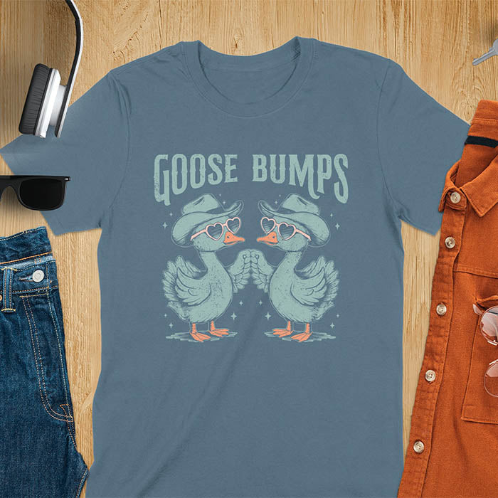 A t-shirt with two geese in cowboy hats and heart sunglasses touching wings. The phrase "GOOSE BUMPS" is positioned above them. This Goose Bumps T-shirt is a silly goose crewneck, funny goose shirt, Retro Vintage Humorous Tee Gift. A Western Sarcastic Silly Meme Shirt, Snarky Sassy Saying Tee-shirt, unhinged tee-shirt, funny sarcasm gift, funny outfit. Ideal gift for goose lover, animal person, Animal Lover Tshirt, gift mom hers. Features kawaiiness cuteness, cute animal clothe, cowboy aesthetic.