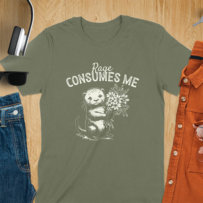 A t-shirt with an otter holding flowers. Text: "Rage CONSUMES ME" above. This dark humor tee features otter cuteness and cuteness kawaii, a mental health meme. A genz meme gift and weird funny t shirt, a funny gag gift or animal lover gag. One of those shirts that go hard, an unhinged tshirt. A mom gift hers or animal person gift with a retro graphic tee style.