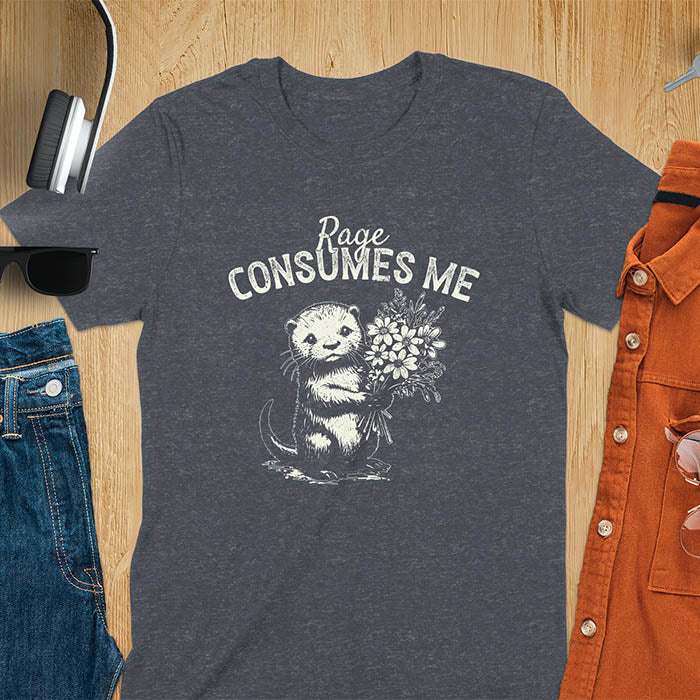 A t-shirt with an otter holding flowers. Text: "Rage CONSUMES ME" above. This dark humor tee features otter cuteness and cuteness kawaii, a mental health meme. A genz meme gift and weird funny t shirt, a funny gag gift or animal lover gag. One of those shirts that go hard, an unhinged tshirt. A mom gift hers or animal person gift with a retro graphic tee style.