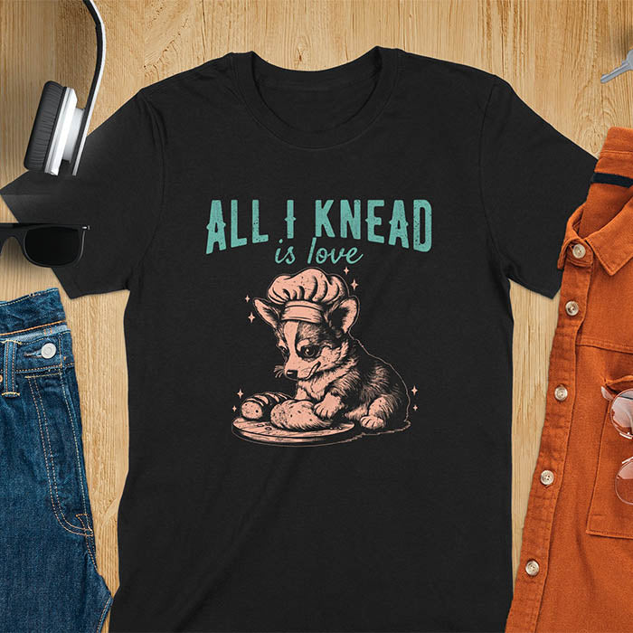 Black t-shirt with a cute corgi baking, featuring cartoon dog in chef hat with All I Knead Is Love text