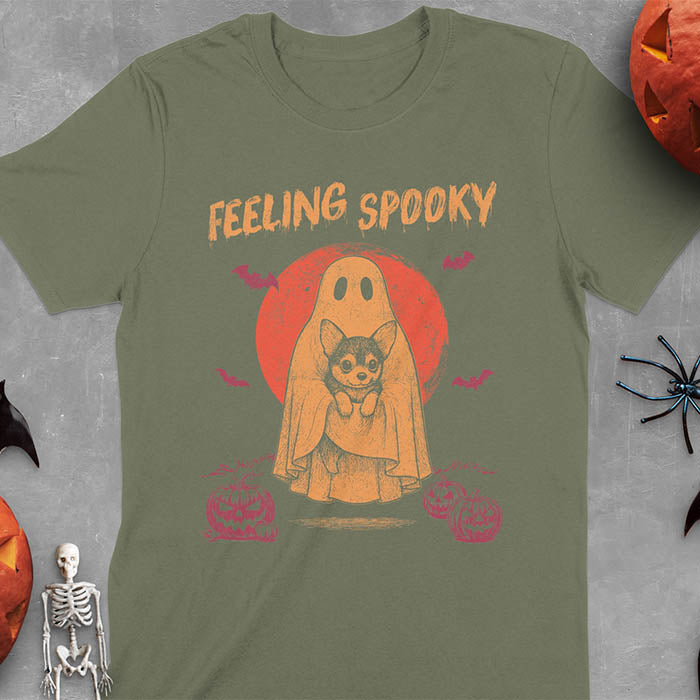 Military Green t-shirt featuring a ghost holding a corgi puppy with 'Feeling Spooky' text above, red moon background with bats and jack-o'-lanterns
