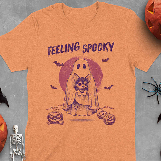 Heather Orange t-shirt featuring a ghost holding a corgi puppy with 'Feeling Spooky' text above, red moon background with bats and jack-o'-lanterns