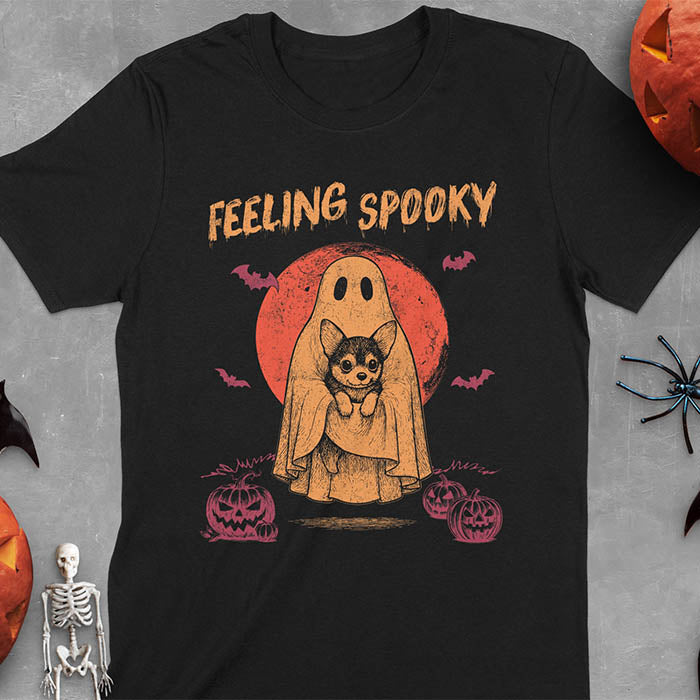 Black t-shirt featuring a ghost holding a corgi puppy with 'Feeling Spooky' text above, red moon background with bats and jack-o'-lanterns
