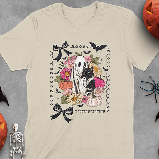 Sand color t-shirt featuring cute ghost holding black cat surrounded by pumpkins, bats, and floral elements in cottagecore coquette style