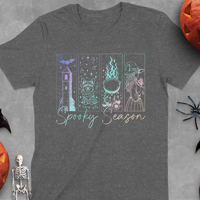 Dark heather t-shirt featuring four neon panels with haunted house, mummy corgi, bubbling cauldron, and witch figure, with 'Spooky Season' text below