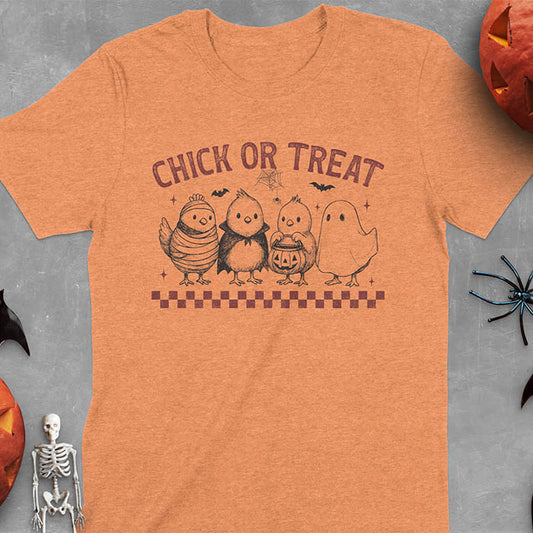 Heather Orange t-shirt with Funny Halloween Chick Or Treat text featuring cartoon chickens dressed as spooky characters including ghost, mummy, vampire, and trick-or-treater
