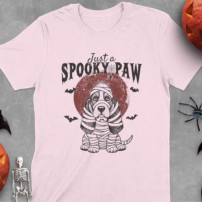 Light Pink t-shirt featuring a cute basset hound wrapped in white mummy bandages with 'Just a SPOOKY PAW' text above