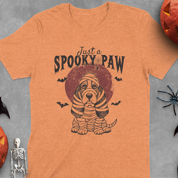 Heather Orange t-shirt featuring a cute basset hound wrapped in white mummy bandages with 'Just a SPOOKY PAW' text above