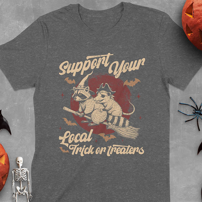Dark heather t-shirt Halloween witch raccoon design featuring opossum pirate on broom with Support Your Local Trick or Treaters text