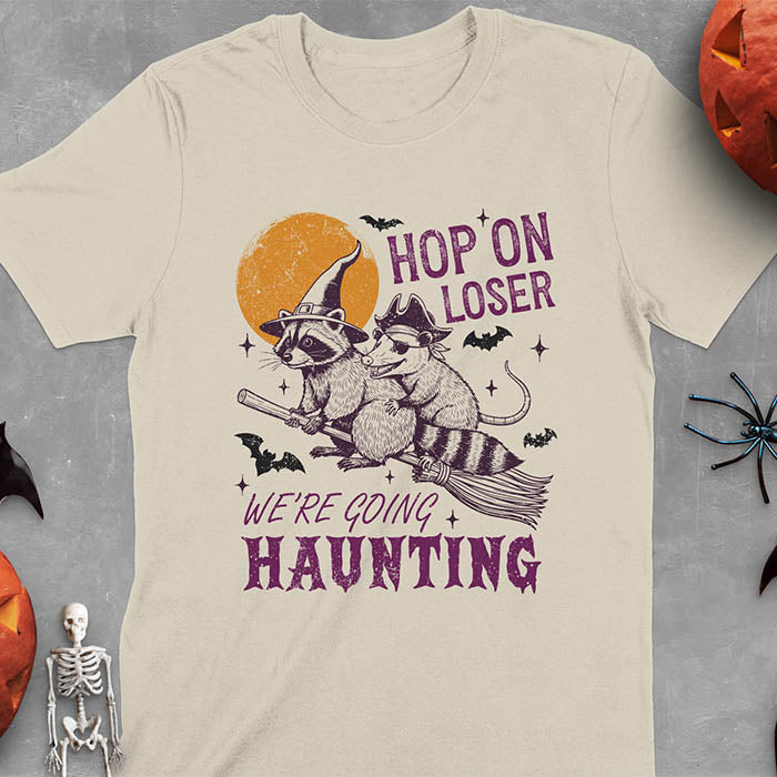 Sand colored Halloween witch raccoon and opossum t-shirt with flying broom animal graphics
