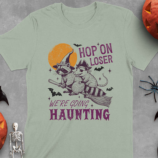 Sage green Halloween witch raccoon and opossum t-shirt with flying broom animal graphics