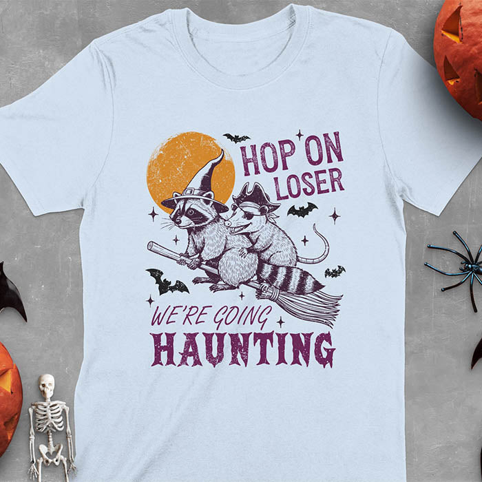 Light blue Halloween witch raccoon and opossum t-shirt with flying broom animal graphics