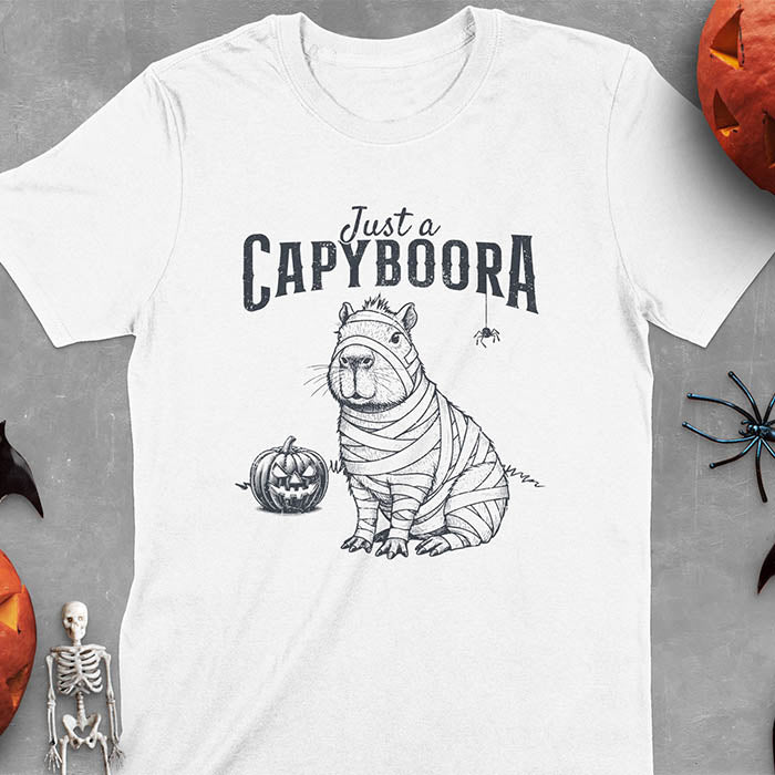 White t-shirt with a Halloween mummy capyboora t-shirt featuring cute capybara wrapped in white bandages with spooky Halloween design