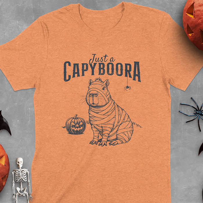 Heather Orange t-shirt with a Halloween mummy capyboora t-shirt featuring cute capybara wrapped in white bandages with spooky Halloween design