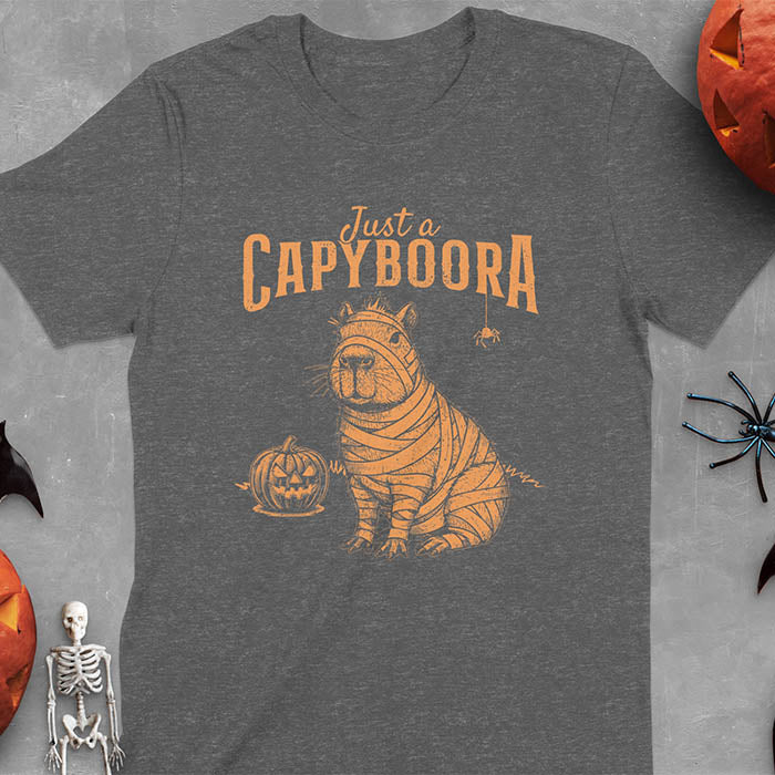 Dark heather t-shirt with a Halloween mummy capyboora t-shirt featuring cute capybara wrapped in white bandages with spooky Halloween design