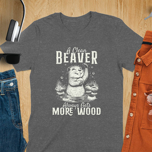 Dark heather t-shirt featuring illustrated beaver bathing in water with text 'A Clean Beaver Always Gets More Wood' - adult humor meme design with cartoon beaver surrounded by water bubbles and tree stumps