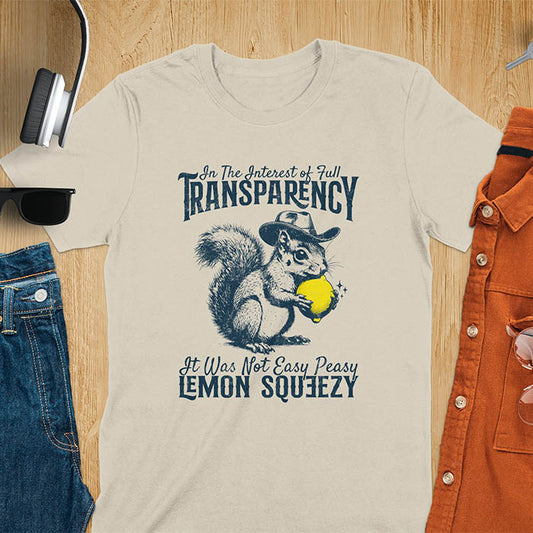Sand color t-shirt featuring illustrated squirrel wearing cowboy hat and holding yellow lemon with text 'In The Interest of Full Transparency It Was Not Easy Peasy Lemon Squeezy' - funny sarcastic meme design