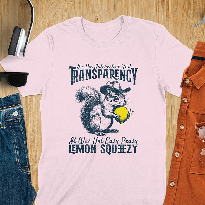 Light pink t-shirt featuring illustrated squirrel wearing cowboy hat and holding yellow lemon with text 'In The Interest of Full Transparency It Was Not Easy Peasy Lemon Squeezy' - funny sarcastic meme design
