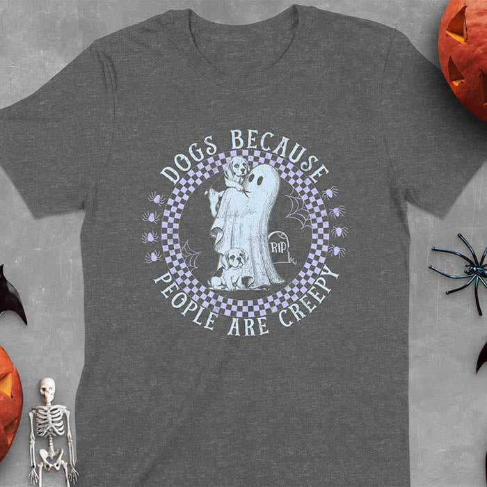 Dark heather Halloween t-shirt featuring a cute ghost holding a beagle puppy with another beagle sitting on the ground next to a tombstone marked 'RIP', surrounded by spiders in a circular checkered border design with text 'DOGS BECAUSE PEOPLE ARE CREEPY'