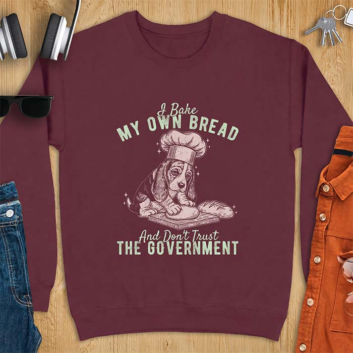 Maroon sweatshirt with a graphic of a basset hound in a chef's hat kneading dough beside a loaf of bread and the text I Bake My Own Bread And Don't Trust The Government