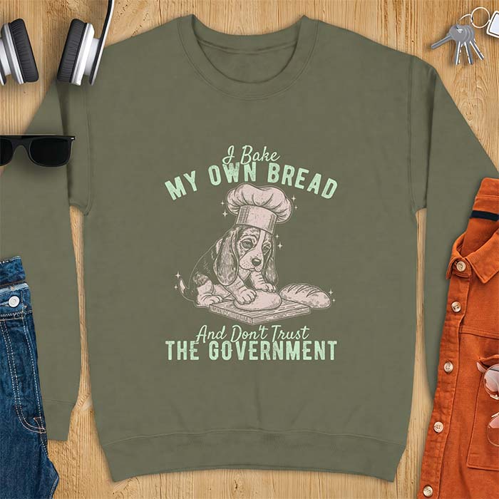 Military Green sweatshirt with a graphic of a basset hound in a chef's hat kneading dough beside a loaf of bread and the text I Bake My Own Bread And Don't Trust The Government