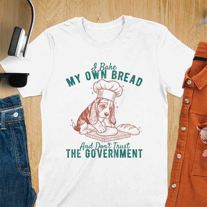 White Basset Hound chef t-shirt with text 'I Bake MY OWN BREAD And Don't Trust THE GOVERNMENT' featuring basset puppy in chef's hat
