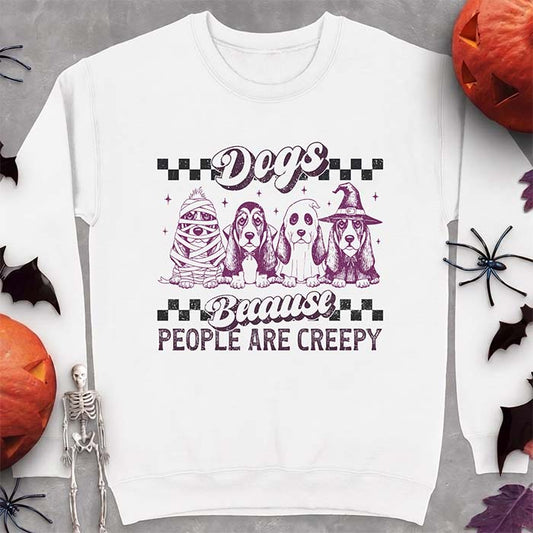 White sweatshirt with a Halloween graphic of four Basset Hound puppies dressed as a mummy, a Dracula, a ghost in a bedsheet, and a witch, with the text Dogs Because People Are Creepy