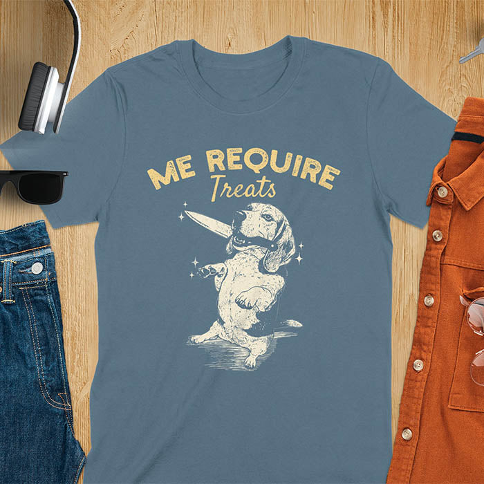 Indigo blue t-shirt with Me Require Treats text, basset hound meme design, and vintage grumpy dog biting on a knife in its mouth illustration