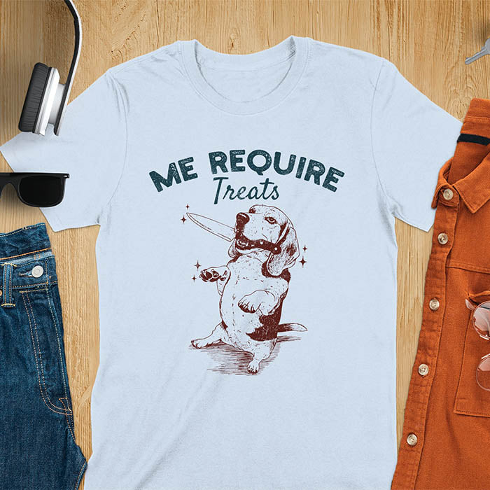 Light blue t-shirt with Me Require Treats text, basset hound meme design, and vintage grumpy dog biting on a knife in its mouth illustration