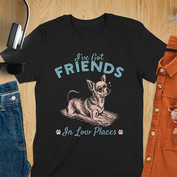Black t-shirt featuring a sitting chihuahua illustration with large ears and paw prints, text reads I've Got Friends In Low Places