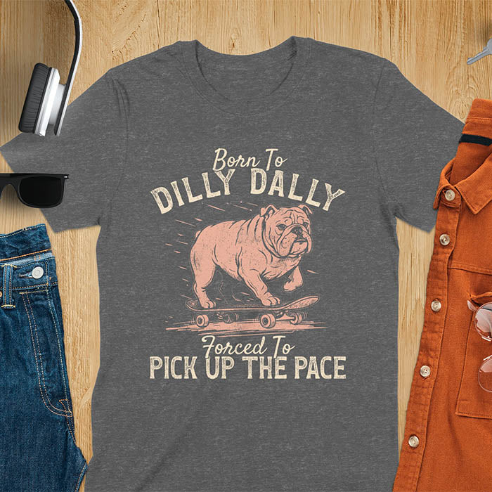 Grumpy bulldog on skateboard illustration with Born To Dilly Dally text and Forced To Pick Up The Pace slogan on dark heather tee